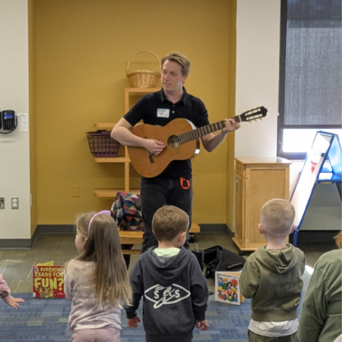 Mr. Robbie playing guitar at storytime